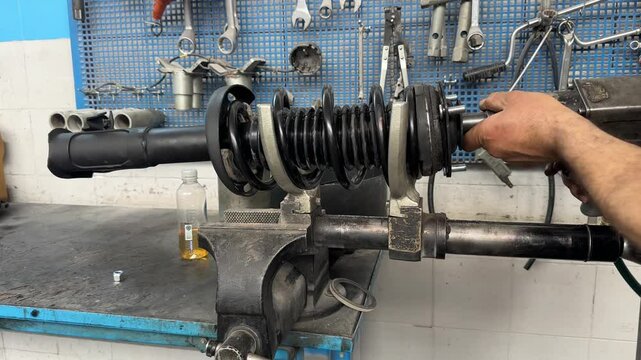 A technician is repairing the shock absorber section of the car.