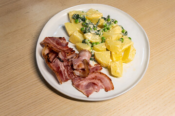 A plate of boiled potato with bacon.