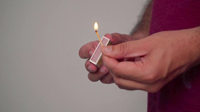Closeup Of Man Lighting Match Stick