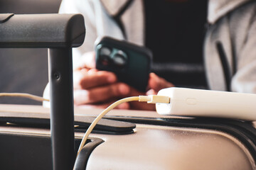 Man charging his mobile phone using power bank portable charger in airport lounge before departure....