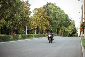 Obraz premium man wearing helmet riding motorcycle on open road