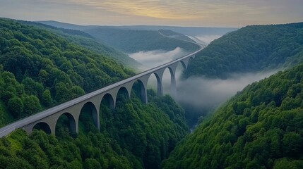 Obraz premium A majestic suspension bridge stretching across a deep valley, lit by golden sunset hues