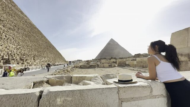 Follow a tourist exploring Keops, the Great Pyramid of Giza in Egypt, a world wonder. Discover the ancient mysteries and architectural brilliance of this site.