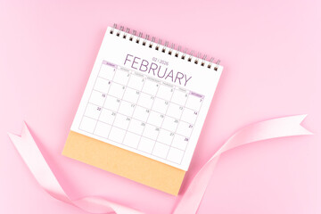 February 2026 desk calendar with pink pastel ribbon.
