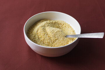 Yellow garri in a white bowl, top view of nigerian garri in a ceramic bowl, fried cassava, garri for eba