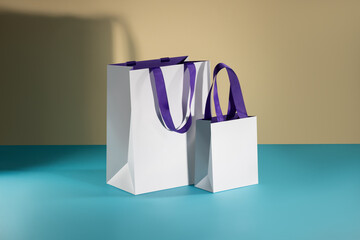 White deluxe glossy paper bag with purple fabric handles