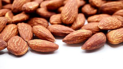 Close-up image of almonds on a clean white background. Highlighting their natural brown tones and smooth, oval shapes