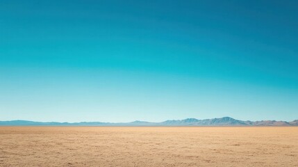 Fototapeta premium Vast expanse of the arid landscape under a clear azure sky with mountain range