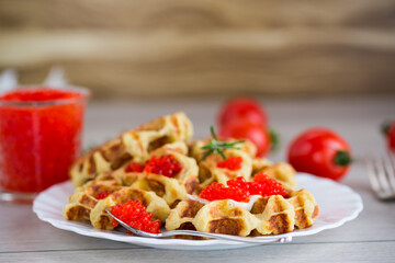Delicious potato waffles with red caviar on a plate
