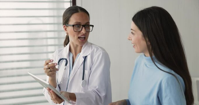 General practitioner in coat showing to clinic patient medical MRI scans images or reports on tablet, explaining health test or lab results, sharing treatment plan, prescribe effective innovative meds