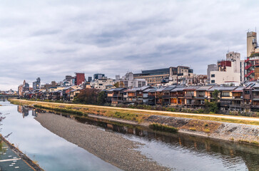 Traditional wooden houses and the reflections on the Kamo river in Kyoto in autumn