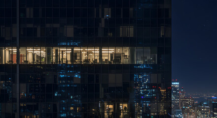 Office Building at Night with Illuminated Windows and City Skyline