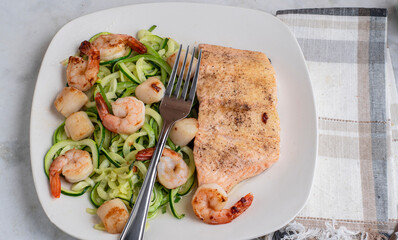 baked salmon  with zucchini noodles, shrimp and scallops