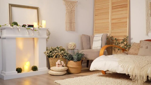 Static shot of a beautiful room with macrame decorations on the wall, fireplace with candles, and baskets with flowers
