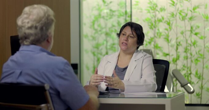 Doctor offering medical advice to patient across desk in clinical setting with clear body language and professional engagement in conversation