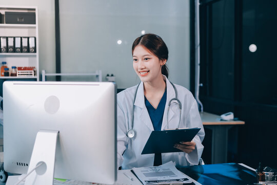 Medical health clinic beautiful Asian doctor working using smart tablet touching, stethoscope diagnosing patient analysis research examination healthcare provider service insurance in modern office