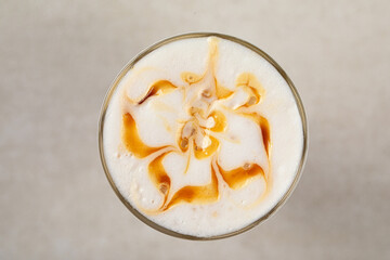 Top view on portion of sweet coffee latte with caramel syrup