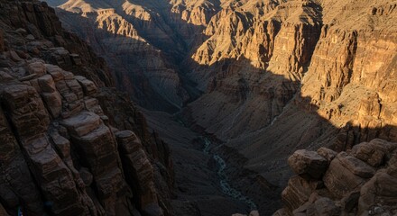 Obraz premium Canyon Landscape View with Cliffside Rocks and River Below in Sunlight