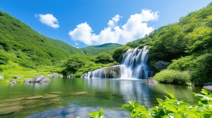 Fototapeta premium Serene waterfall cascading into a tranquil pool amidst lush greenery and a vibrant blue sky