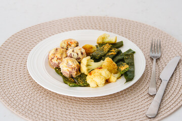 Balanced meal with cheesy meatballs and vegetables.