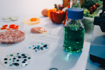 Team Asian scientists in a lab conducting food research using a microscope and lab equipment,...