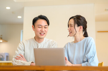 Obraz premium パソコンを見て相談をする日本人男女