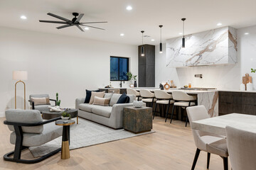 The living room has a spacious couch, chairs, and a ceiling fan