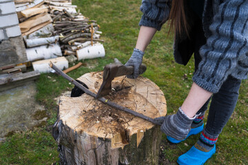 Cutting branches on the deck. A girl cuts a branch with an axe