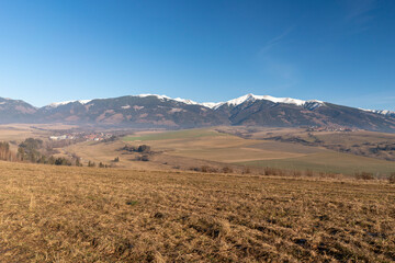 In the distance, the snow-capped mountains rise up – the majestic Tatra Mountains in Slovakia. Their snow-white peaks contrast effectively with the sky, creating an atmosphere of tranquility and natur