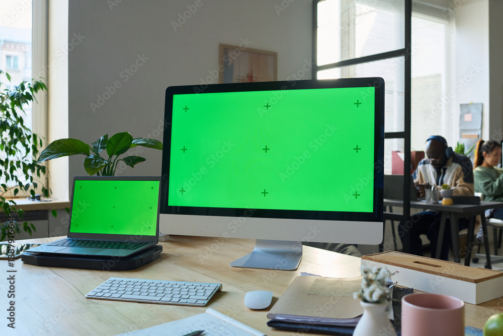 Poster Desktop computer and laptop with chromakey screens standing on workplace of modern programmer or designer