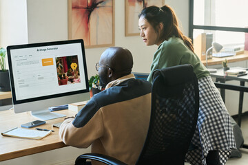 Two programmers looking at screen of desktop computer while using AI image generator and creating...