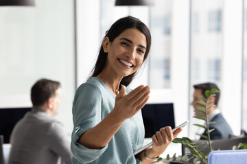 Friendly young Hispanic recruiter woman inviting job candidates to join team. Happy businesswoman...