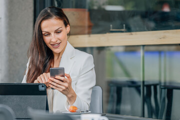 business woman with laptop and mobile phone in cafe working