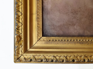 Fragment of old gilded cracked picture frame with canvas painted in dirty grey colour. Close-up....