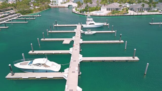 Aerial drone footage around Bimini Bahamas in the vicinity of the cruise terminal with beautiful white sand beaches and abandoned vacation houses with pools and dock.