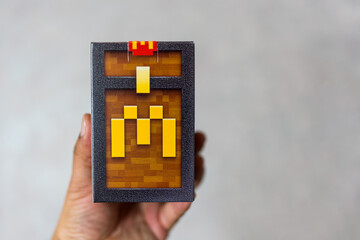 Fototapeta premium Bangkok, Thailand - April 6, 2025 : Holding a blind box toy from McDonald's collaboration with Minecraft movie limited edition.