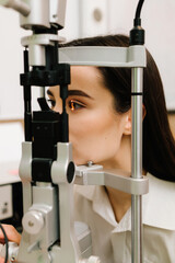 Girl is visiting ophthalmologist for eye examination. Ophthalmology procedure with slit lamp for...