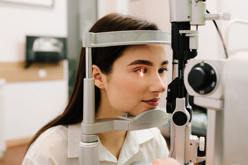 Ophthalmology procedure with slit lamp for eye and cornea checkup. Girl is visiting ophthalmologist...