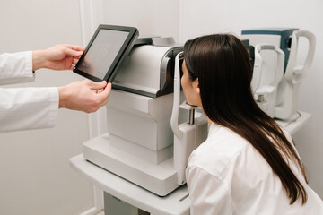 Eye exam with modern autorefractor and OCT machines. Autorefractor measures refractive errors, helping determine prescriptions for glasses or contact lenses with high accuracy and efficiency.