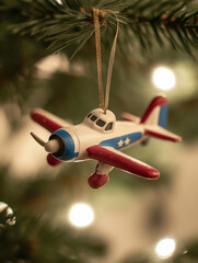 Vintage toy airplane Christmas ornament hanging on decorated tree branch with holiday lights and festive bokeh background

