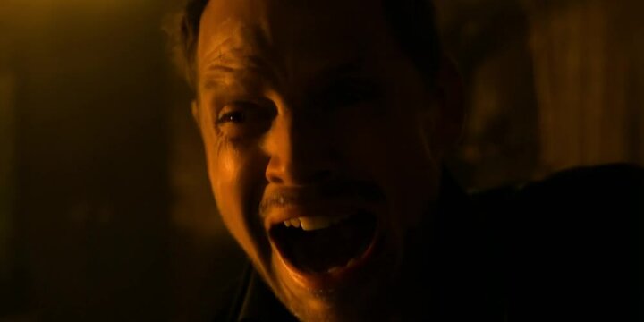 Man screaming anguish close-up intense emotion dramatic lighting facial distress pain raw expression psychological turmoil dark contrast Short brown hair, mouth wide open, eyes wide looking upward.  
