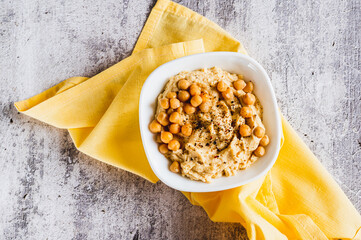 Close up of homemade hummus with chickpeas in a bowl on the table top view