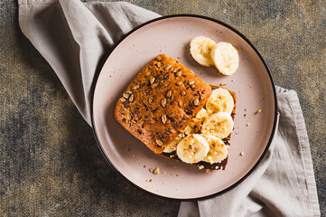 Close up of sweet sandwich with chocolate butter, banana and nuts on a plate top view