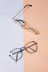 Glasses, set of glasses with clear lenses, on white and peach background, top view