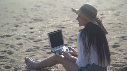 Young freelance women working with her laptop on holiday at the beach .