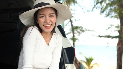 Young Asian women on vacation with her car at the beach Thailand.