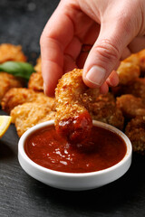 Crispy breaded scampi nuggets with sauce on stone board