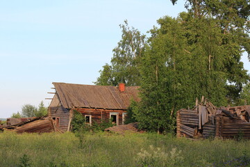 Obraz premium abandoned uninhabited houses in old villages from the times of collective farms and collectivization in the Soviet Union. 1930-1940-1950s of the last century, surrounded by forests and fields