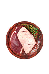 Fresh raw duck breasts, on a wooden chopping board, with herbs and spices, on a white background, no people