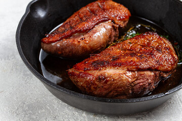 roast duck breast, in a frying pan, with spices and herbs, close-up, no people,